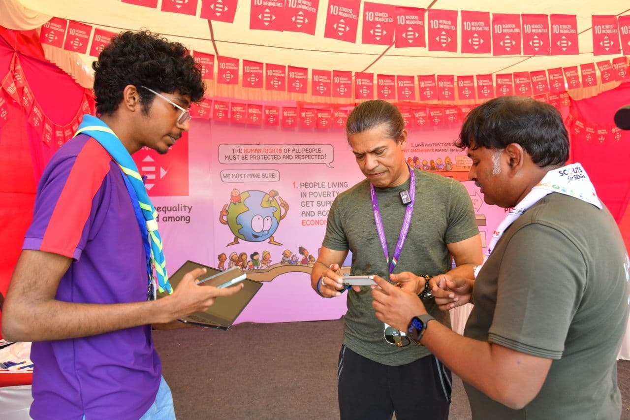 Me showing the QR scanner to two officials inside the Global Development Village marquee