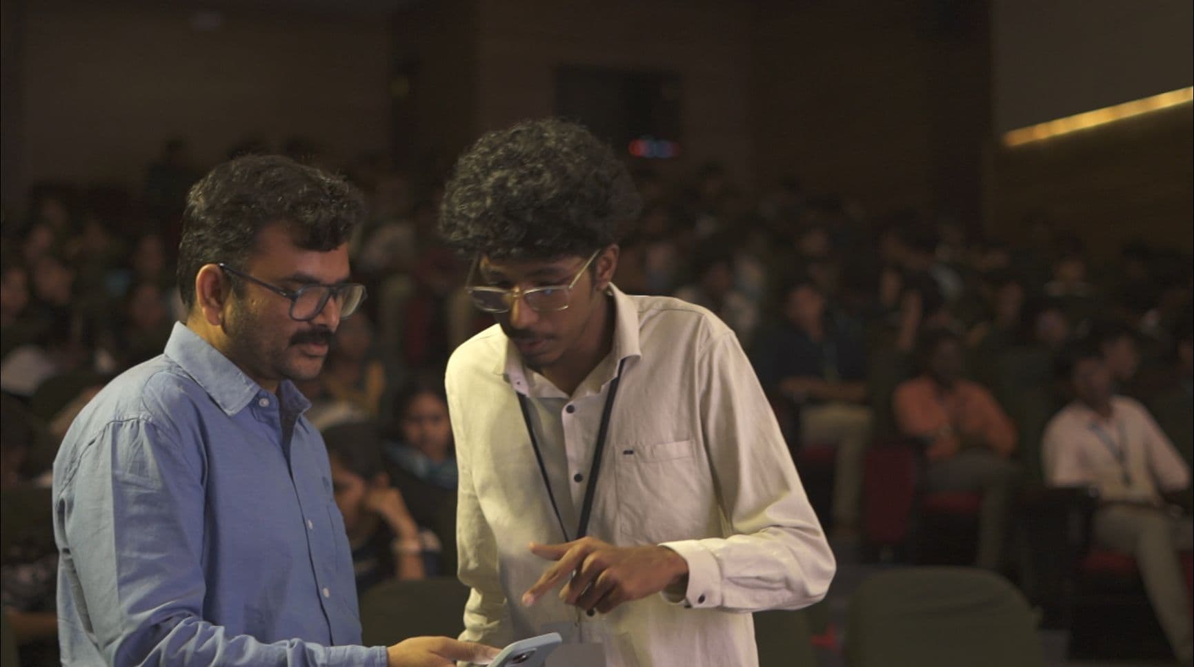 Me and one of the faculty checking something on a phone mid-event, hall packed behind us